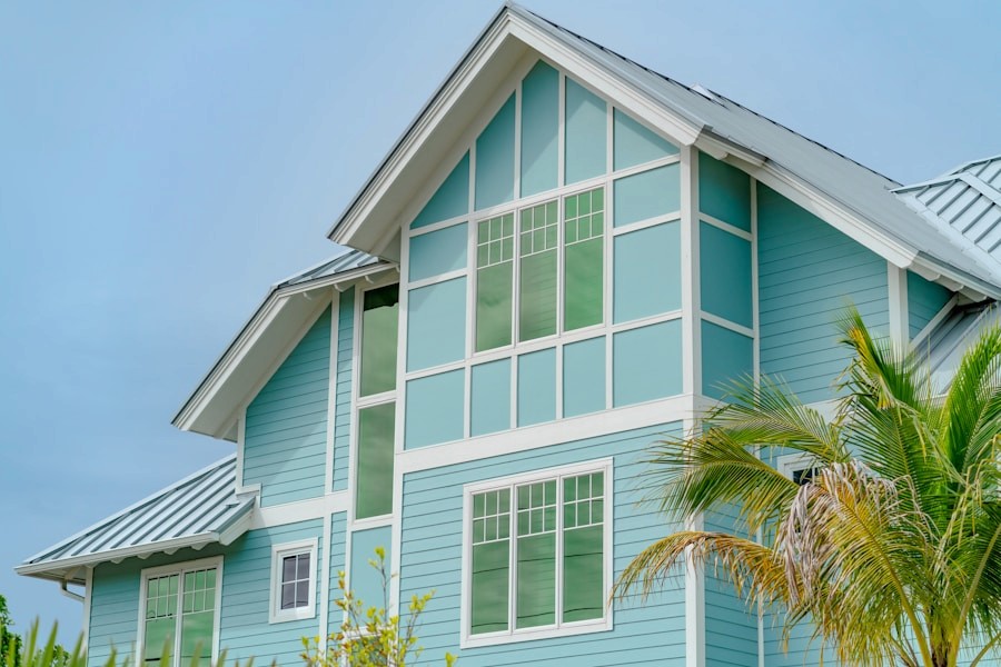 Blue coastal-style home exterior with siding and palm trees