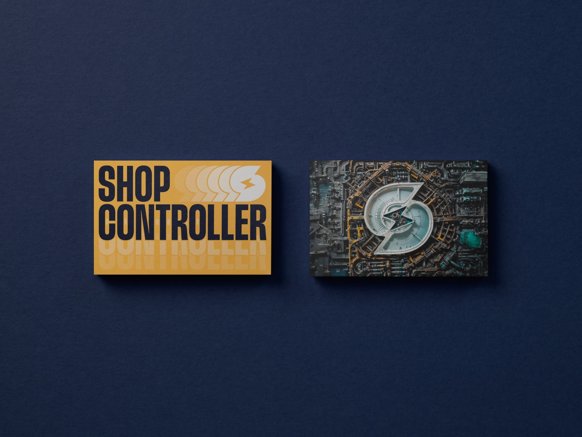 The fronts of two business cards: - Showing the Shop Controller logo and a playful rendition of the Shop Controller 'S' logo - Showing the Shop Controller 'S' icon In an engine, both the fronts of the business card are sitting on top of a dark background with soft lighting 