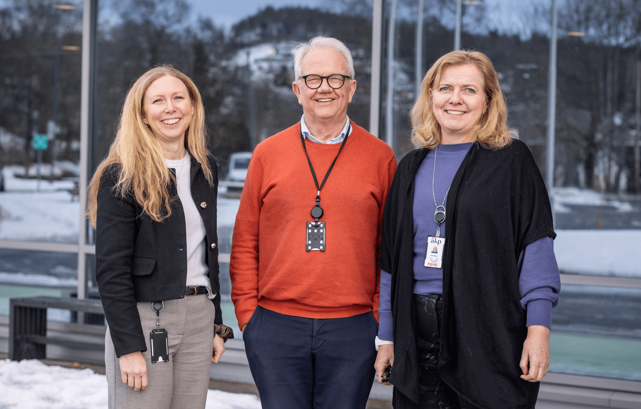 A person wearing a virtual reality headset stands in front of multiple screens, engaged in a digital experience.