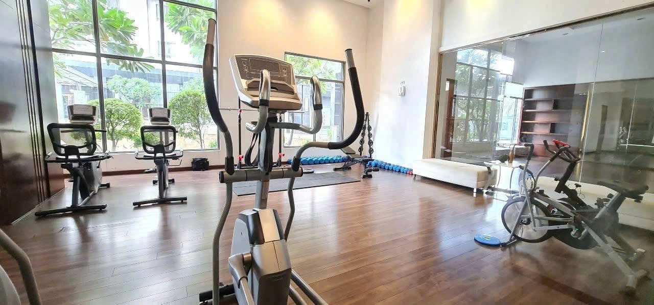 Modern bathroom with illuminated mirror, stone sink, and warm lighting.