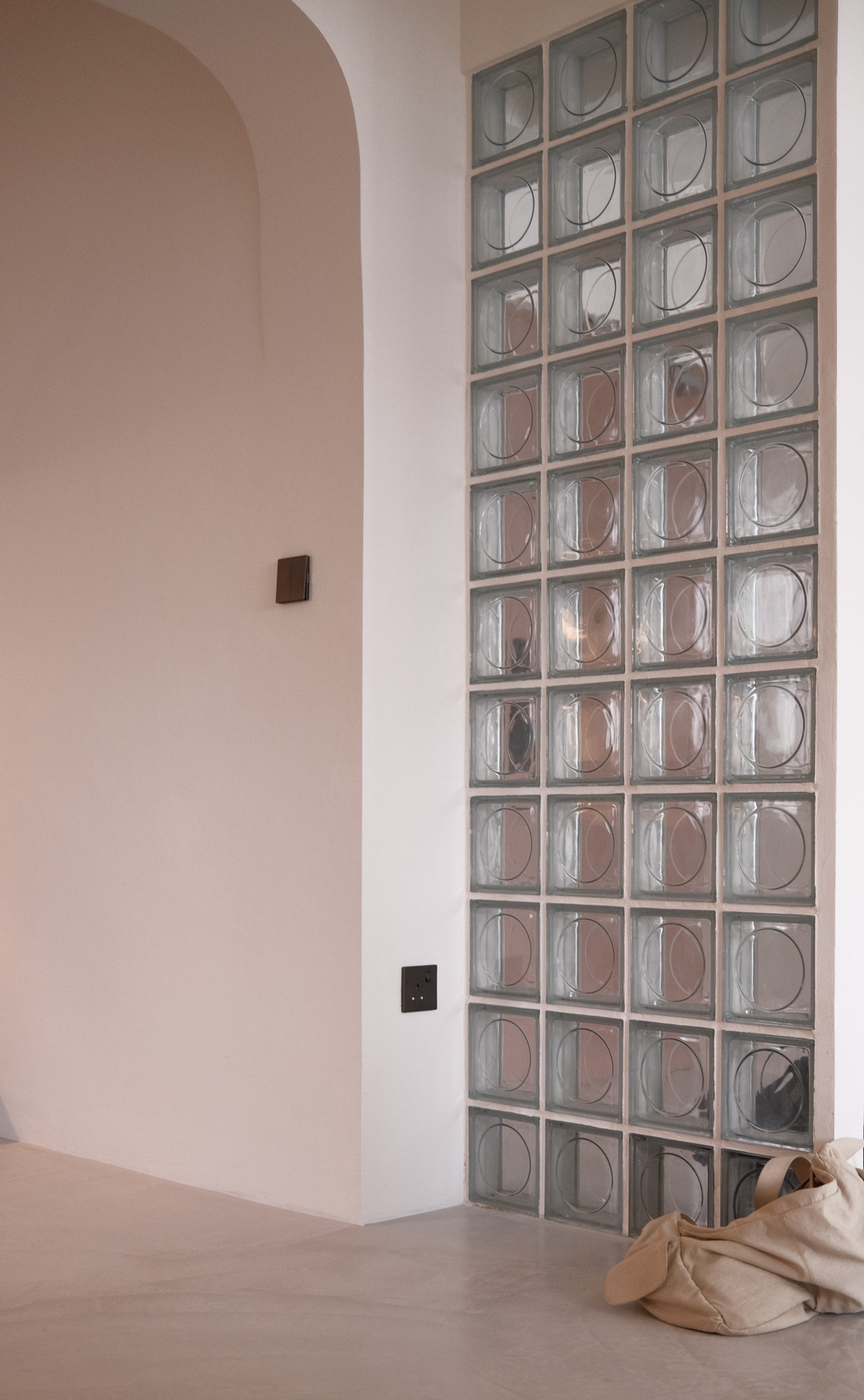 Feature glass block wall with gentle curves in Tampines Wabi-O, blending privacy and light in a contemporary open-plan layout.