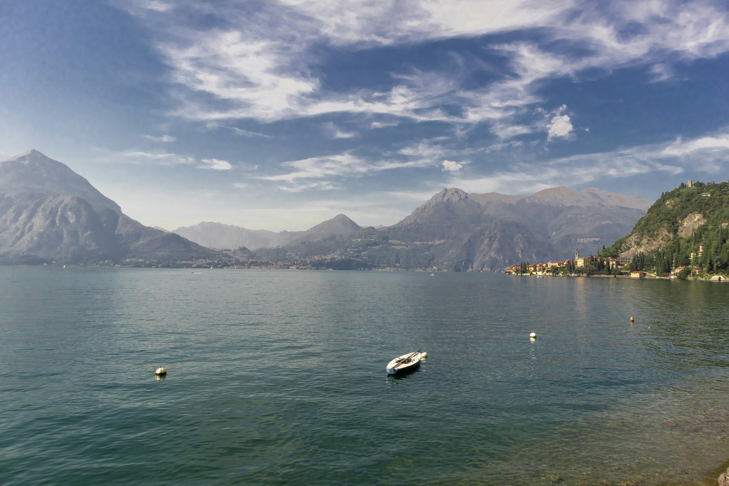 A boat crossing the lake below the mountains