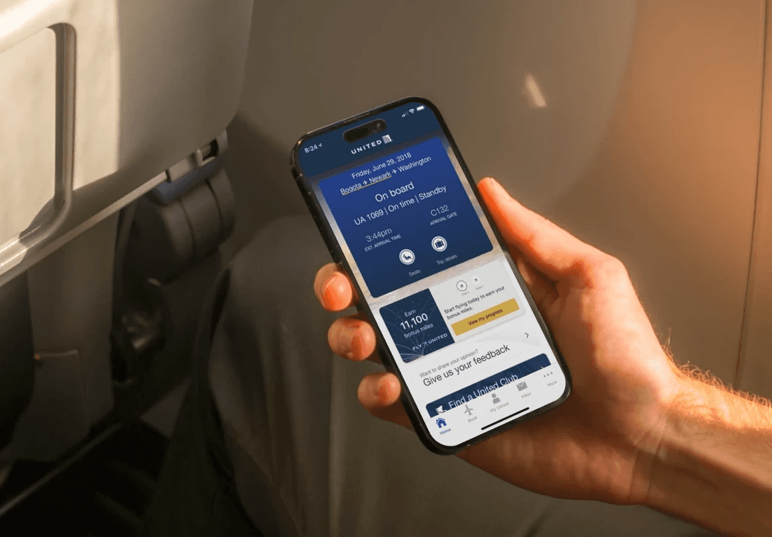Traveler holding an iphone with the new United App open