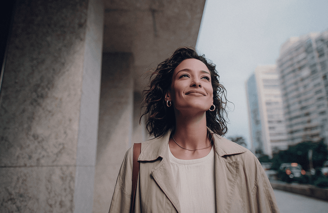 Profissional de legal design sorrindo ao ar livre.