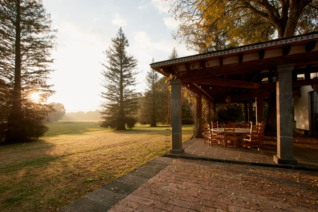 Área de convivencia exterior de Cobertizo con vista al jardín al atardecer, Jilotepec