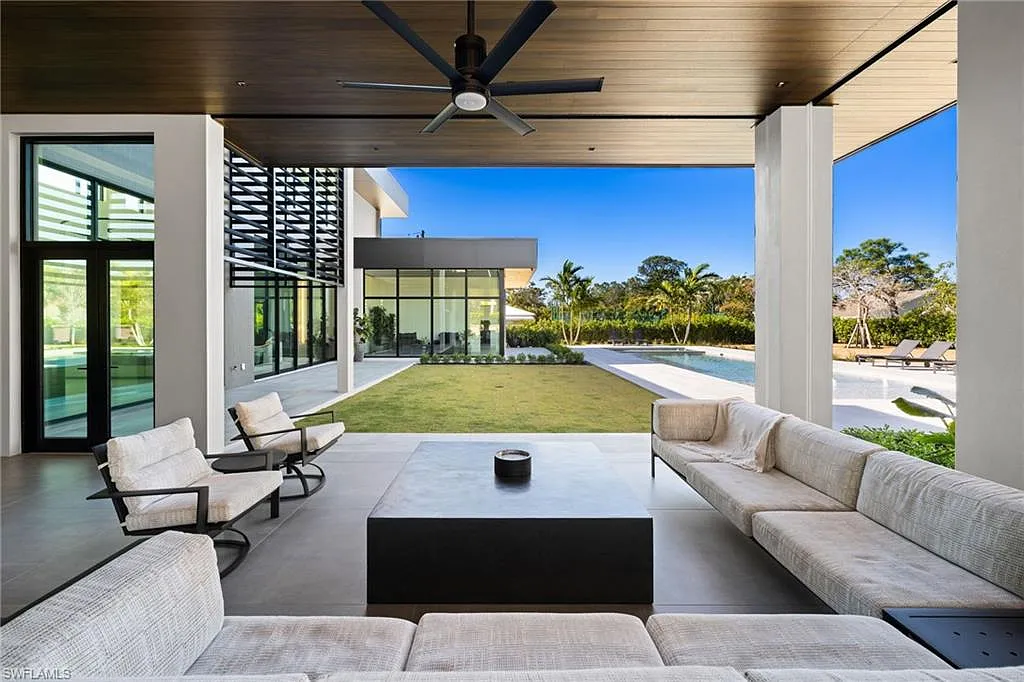Covered lanai with outdoor living and dining space overlooking the pool