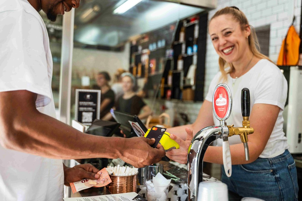 a bar business owner processes a credit card payment with a Teya reader