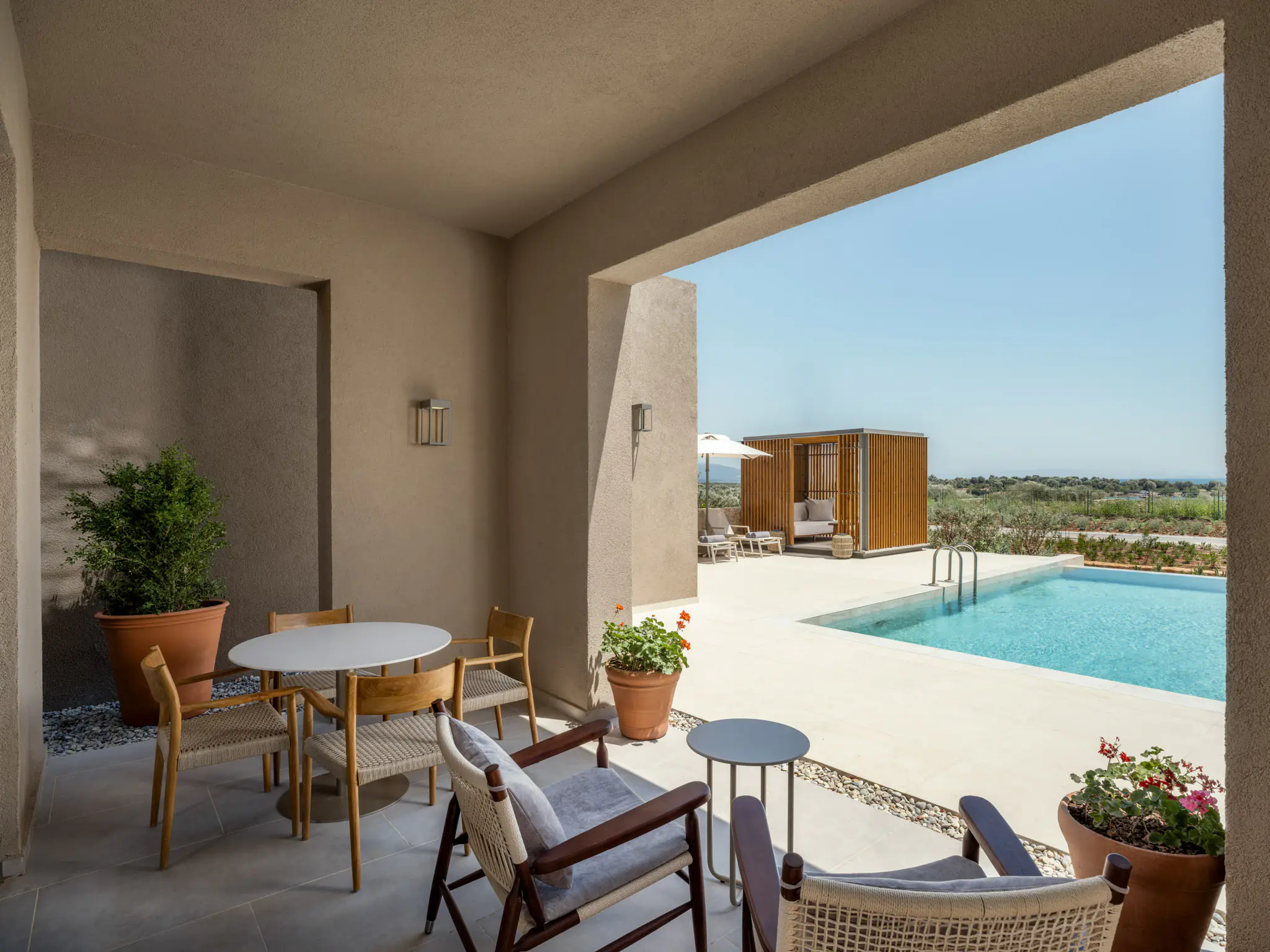 Shaded terrace of the Grand Duplex villa with seating and a private pool