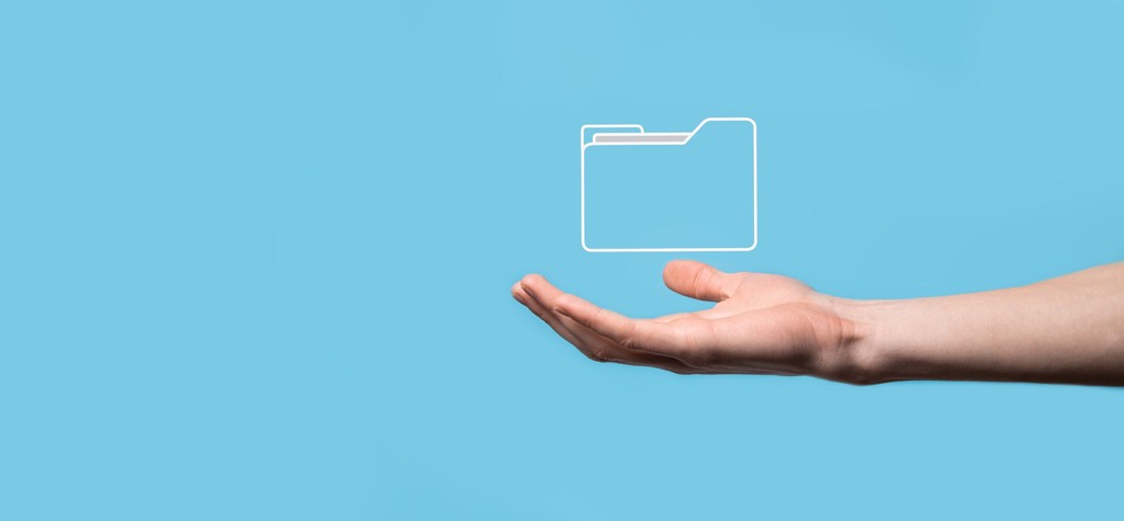 Mão sustentando ícone digital de pasta de arquivos, representando gestão de documentos e armazenamento de dados em nuvem - FindUP - Governança de TI