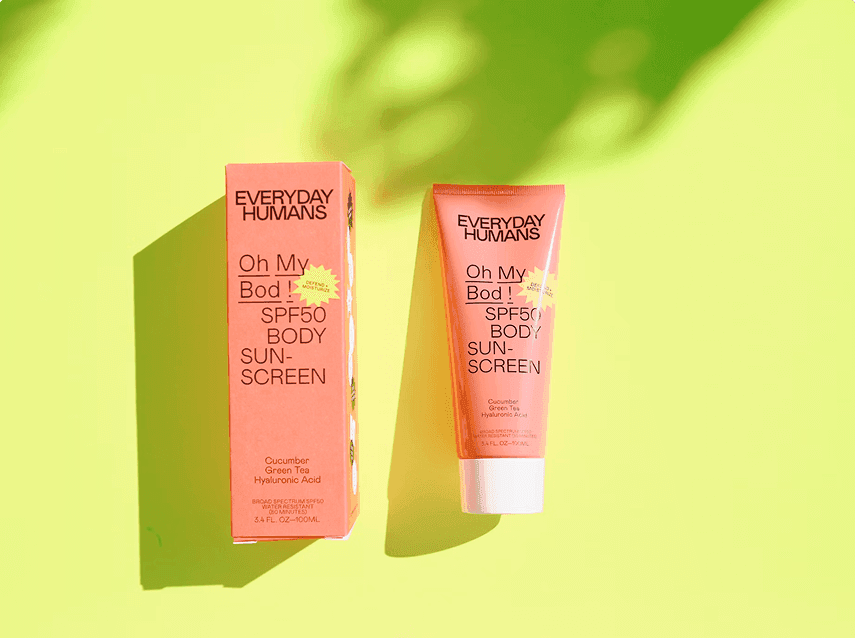 Everyday Humans Oh My Bod SPF50 body sunscreen and packaging displayed on a bright yellow background with soft shadows.