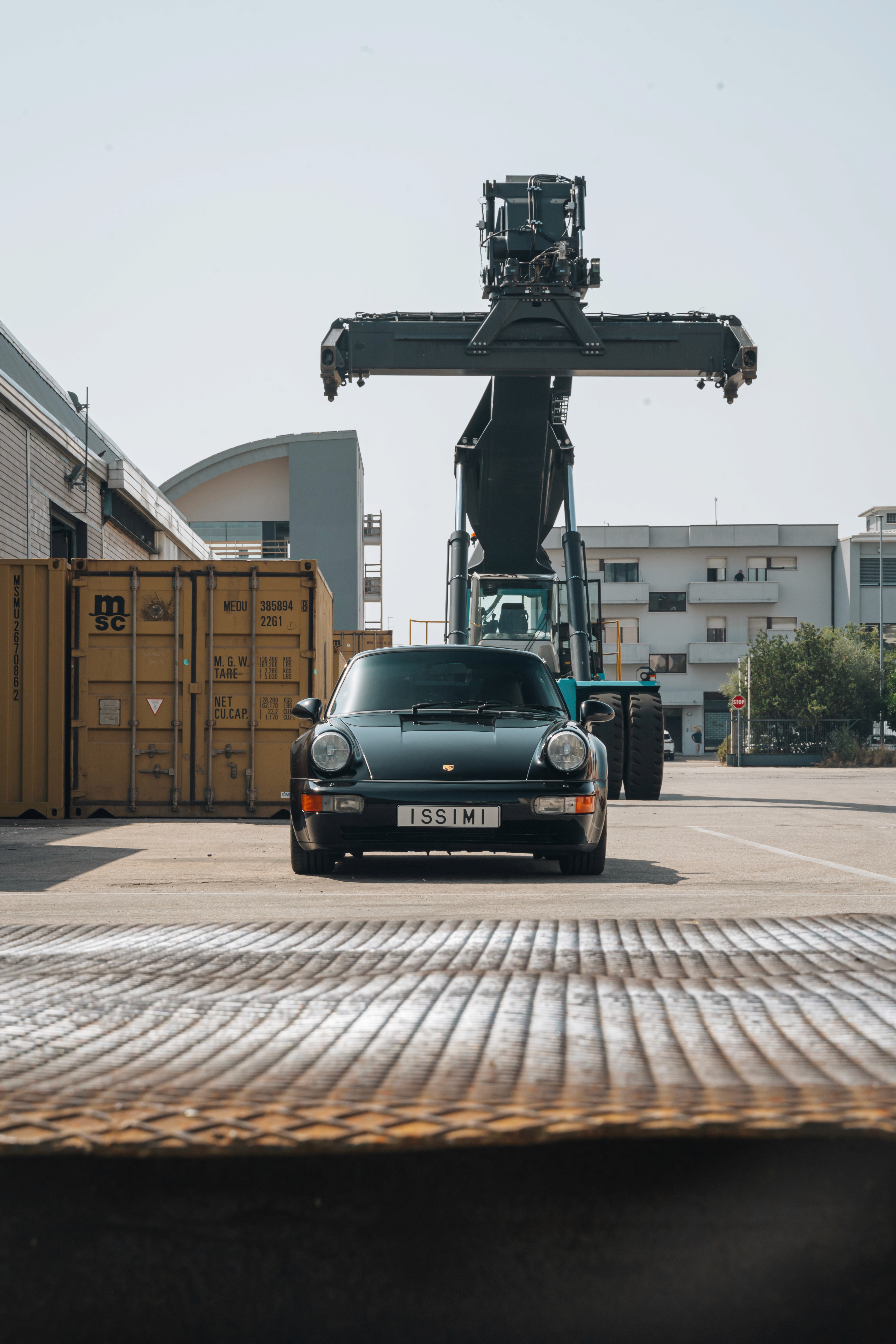 porsche 964 turbo nera in zona industriale con gru