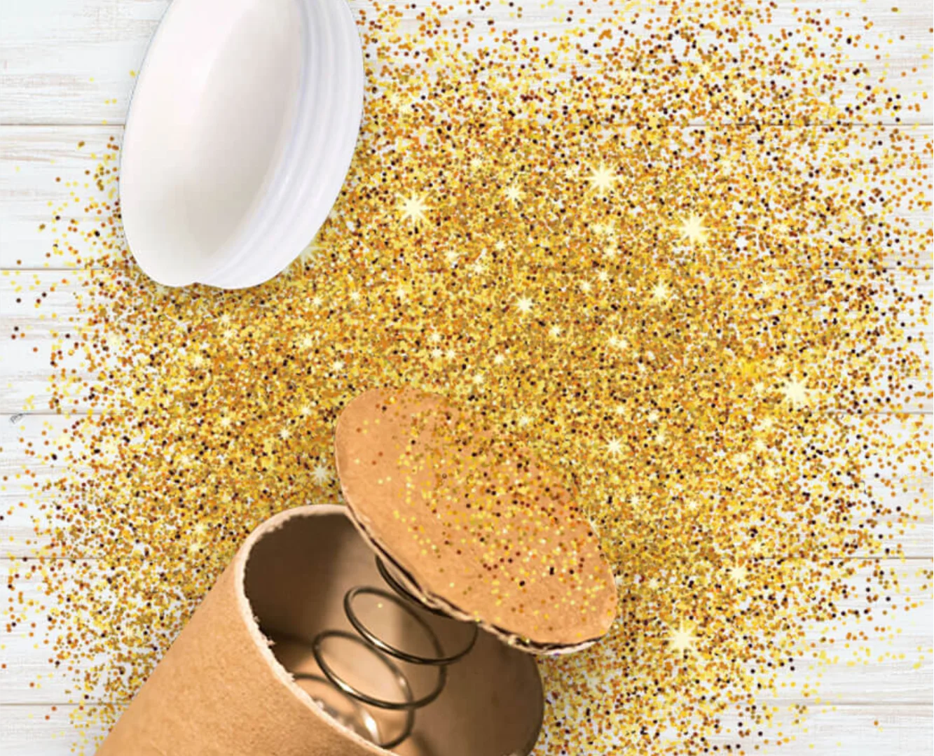 High-impact product action shot for Glitter Bomb Your Enemies, featuring a spring-loaded cardboard tube mid-explosion with a burst of gold glitter on a white wooden background.