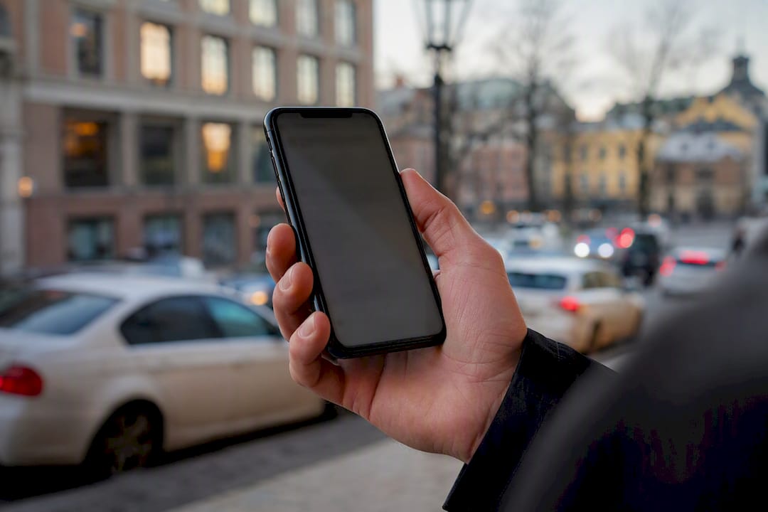 Hånd som holder mobiltelefon med tilbud om bilsalg