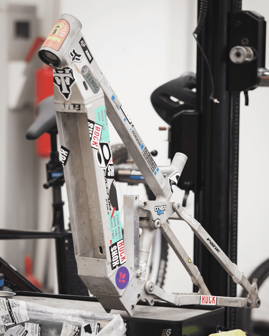 Aluminum frame prototype covered in decals sitting on table in workshop.