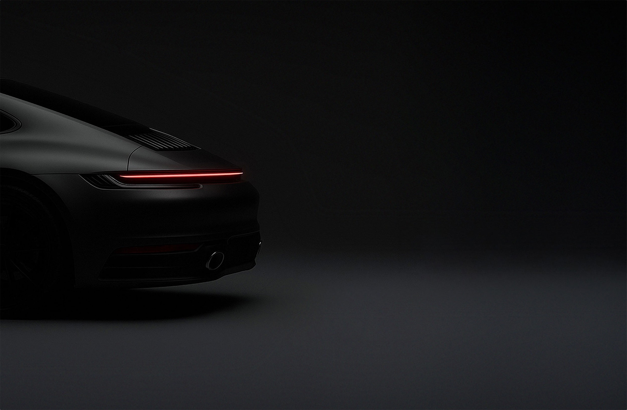 Black sports car with taillight on.