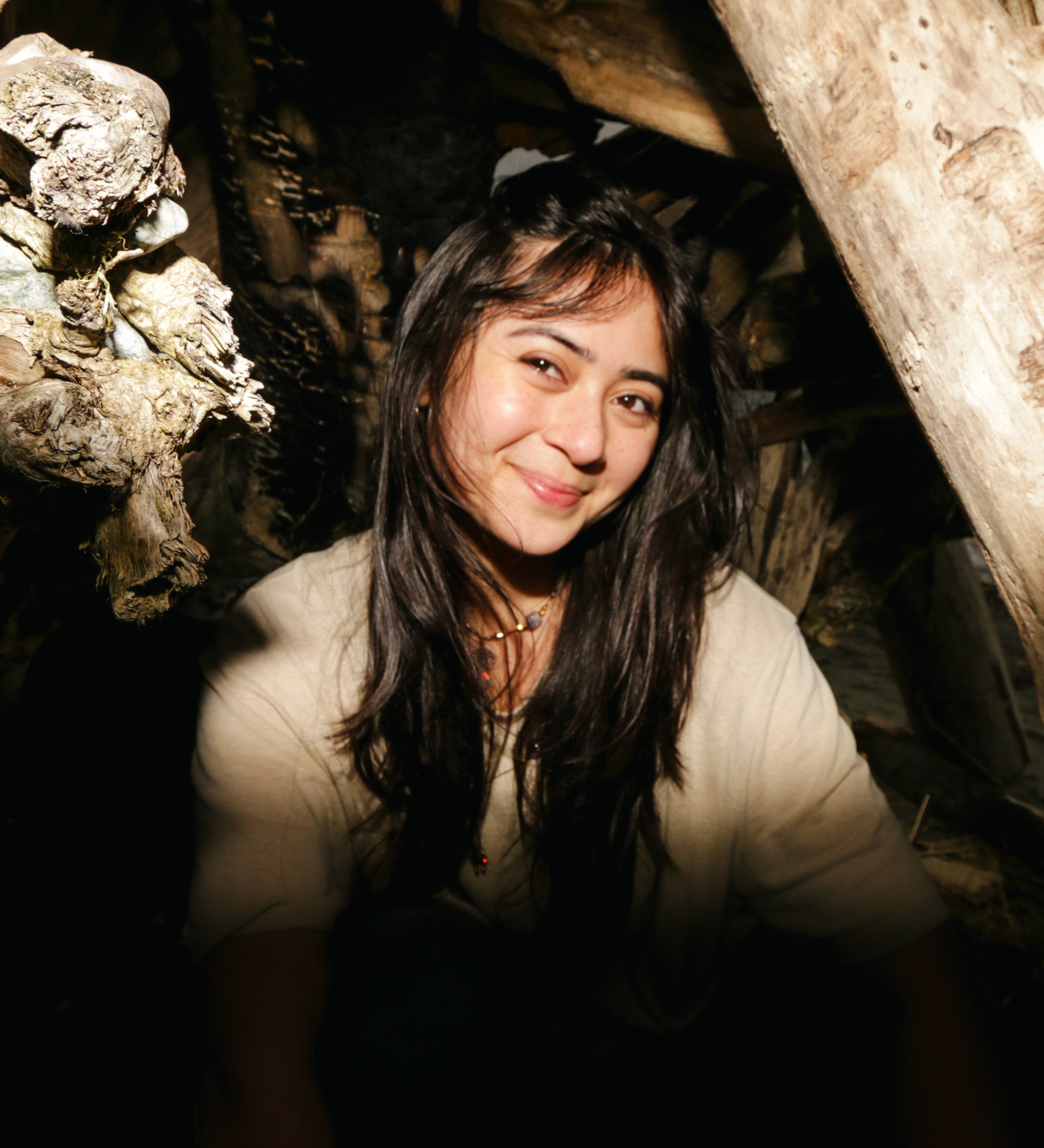 A thoughtful young person with dark hair gazes to the side, captured in soft black and white lighting.