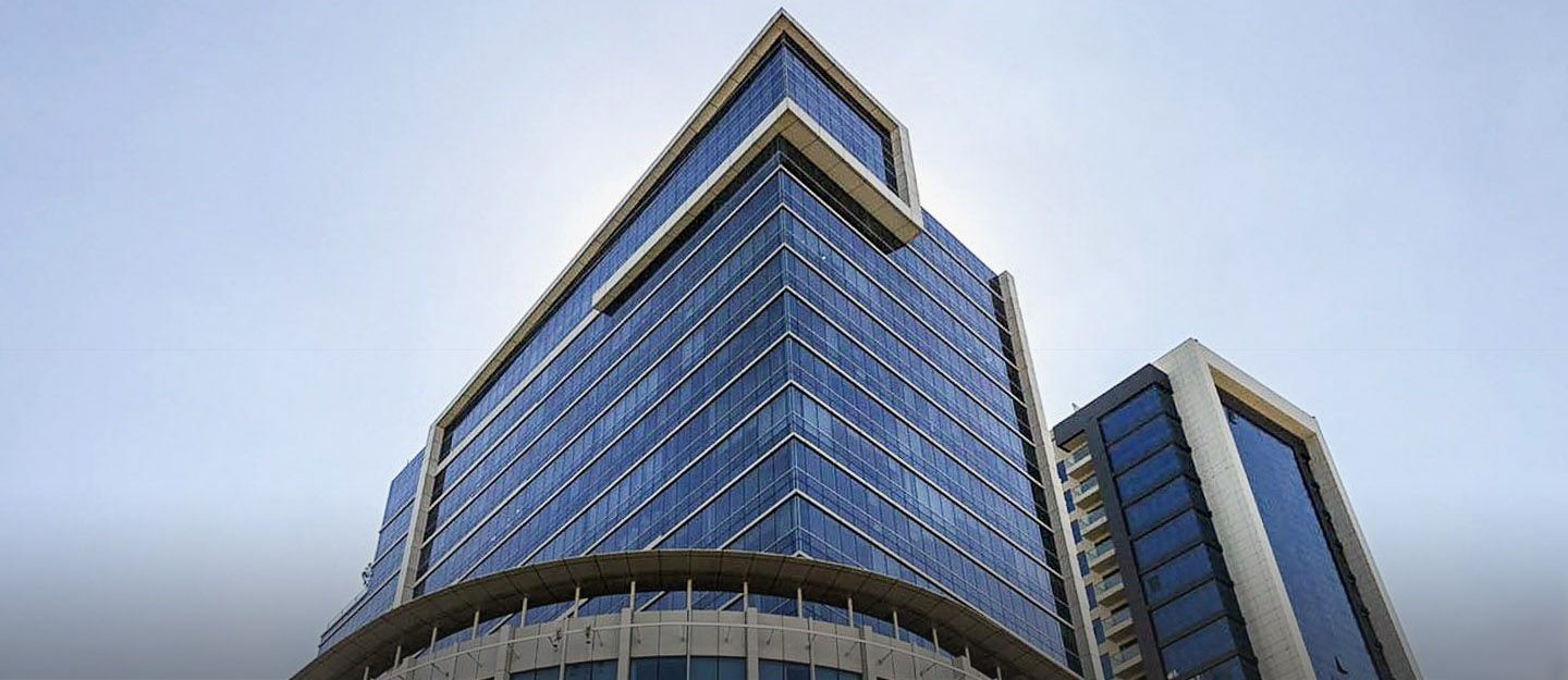 Modern glass facade of a high-rise tower, premium property investment opportunity by real estate agent.