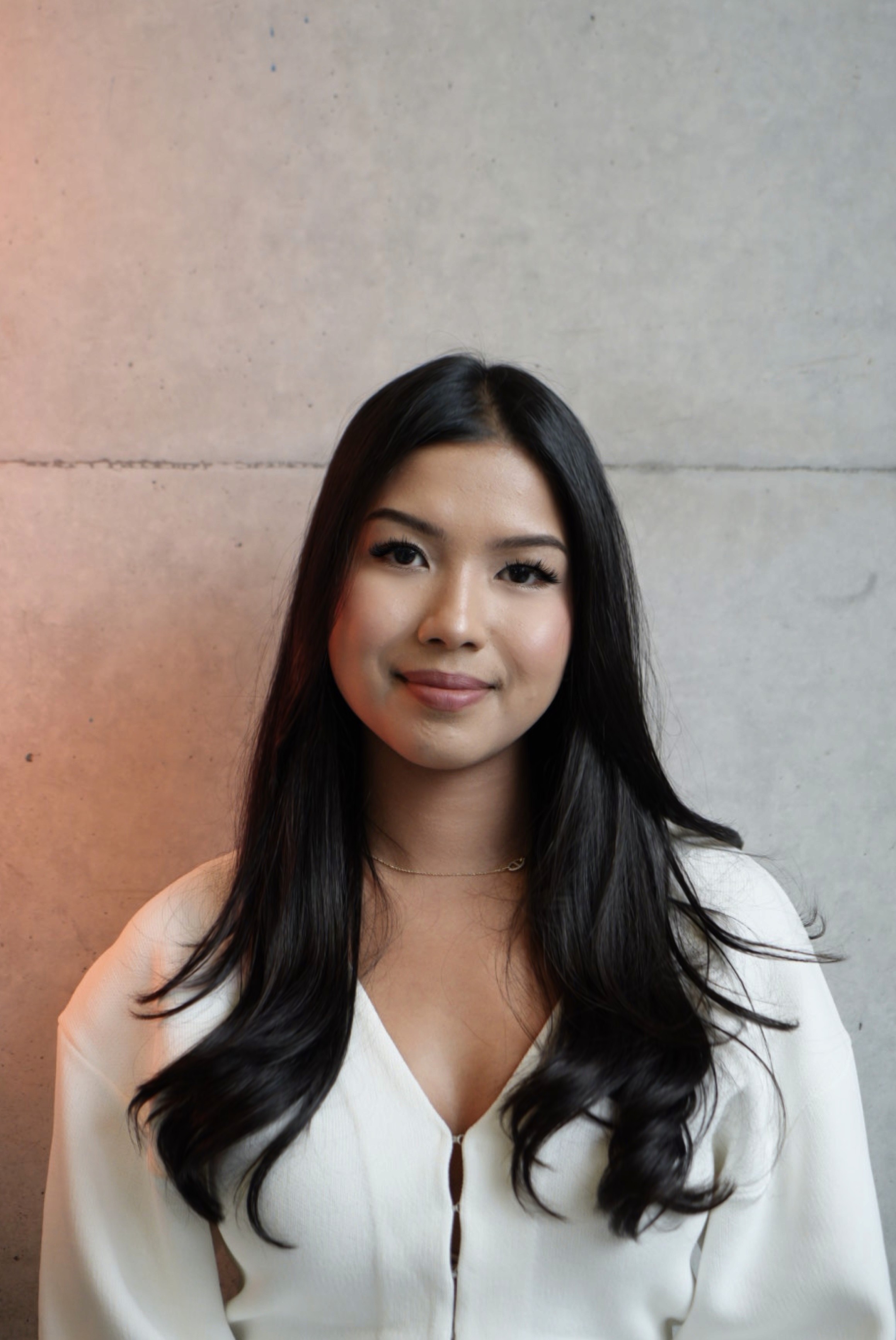 Portrait of a person in a pink sweater against a light background