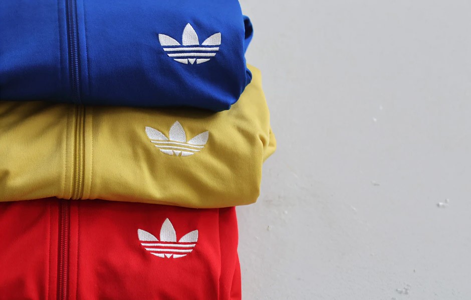 Adidas tracksuit tops stacked on top of ech other