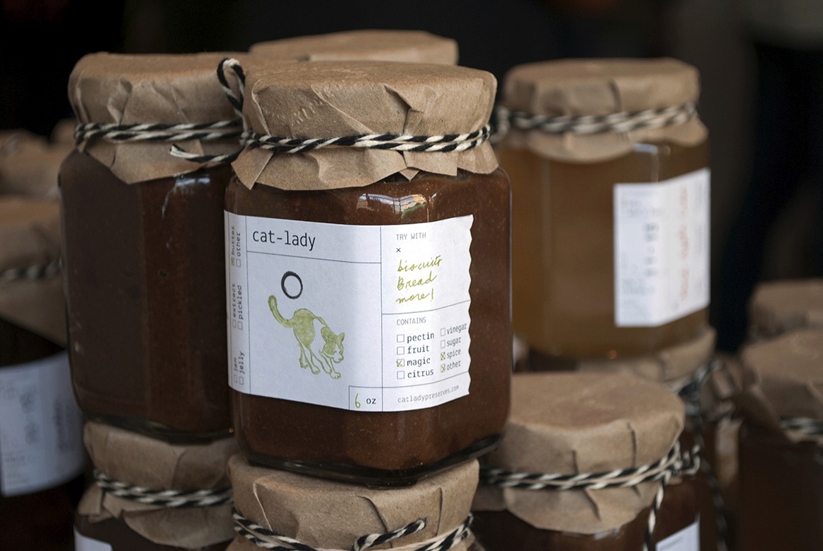 A photo with some jars that have different design labels on them.
