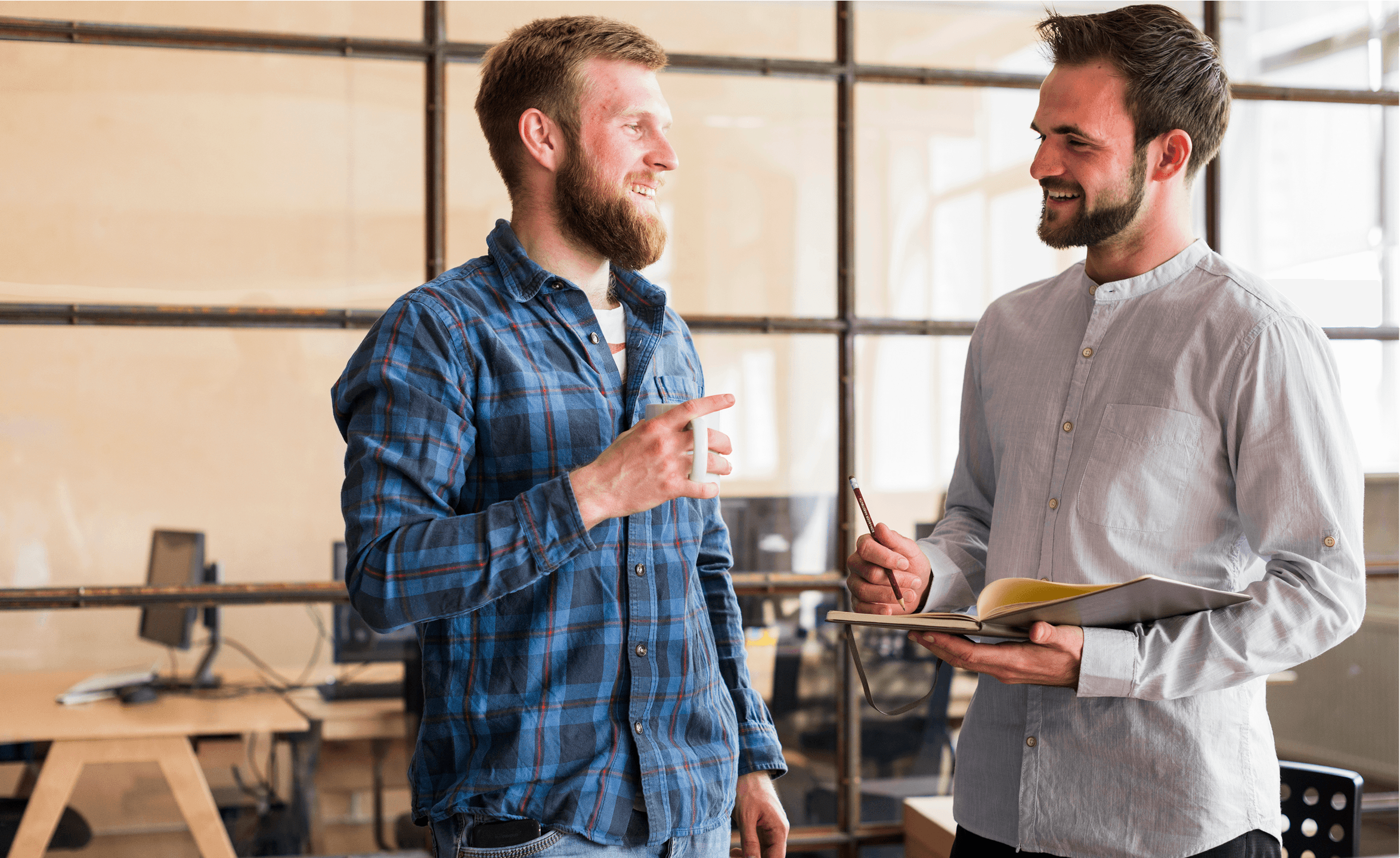 Two men smiling and talking in a modern office.