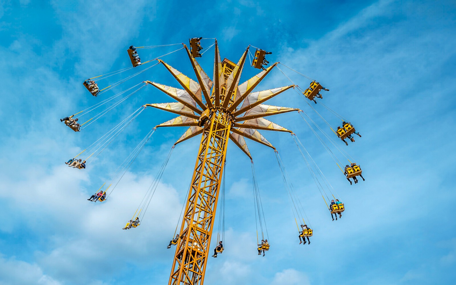 Parc Astérix swing ride with people enjoying the aerial view.