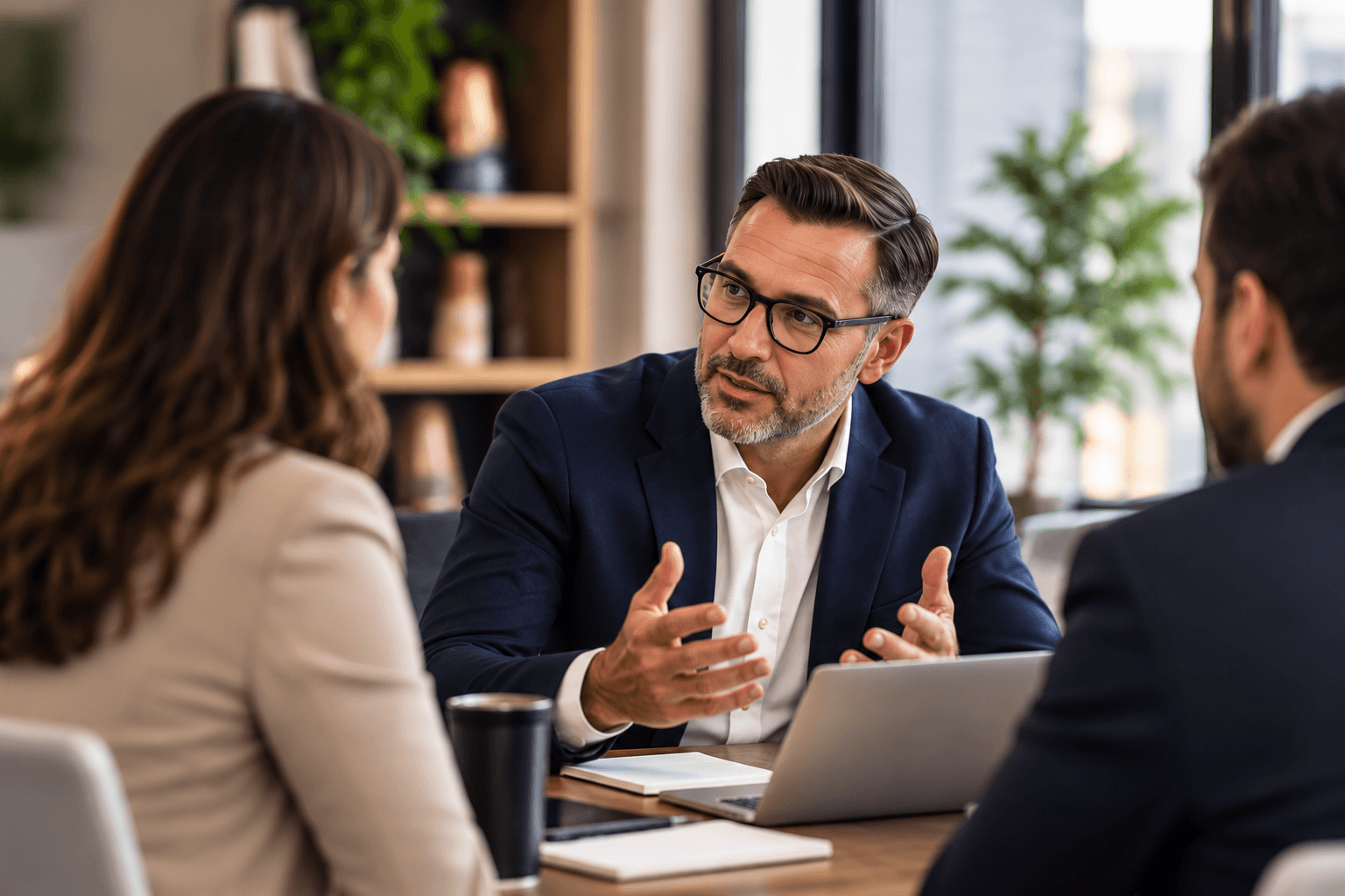 Senior consultant speaking with executives around a table