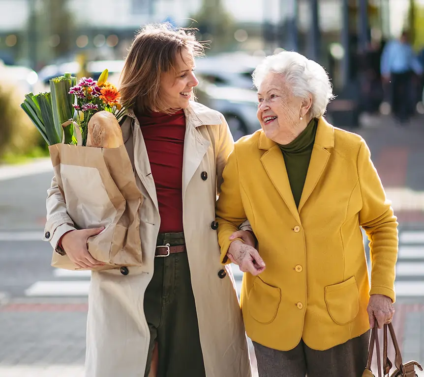 Caregiver and senior walking home together after running errands — part of 24/7 in-home care