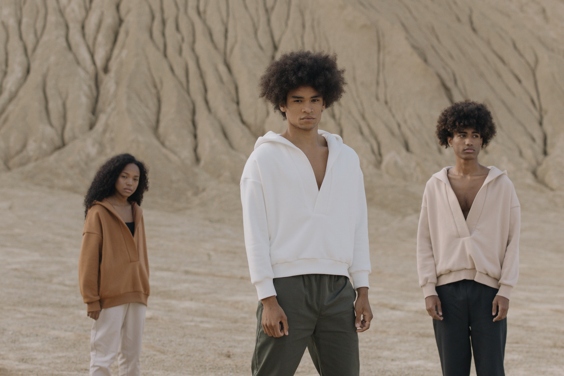 Three people standing in a desert