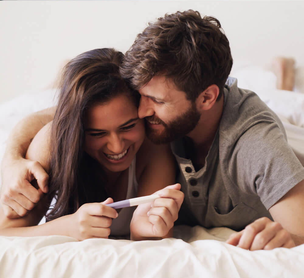 man and woman with pregnancy test embracing