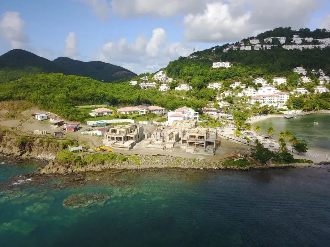 Aerial view of new beachfront villa foundations during construction at Windjammer Landing Resort, St. Lucia, set on a rocky coastal point.