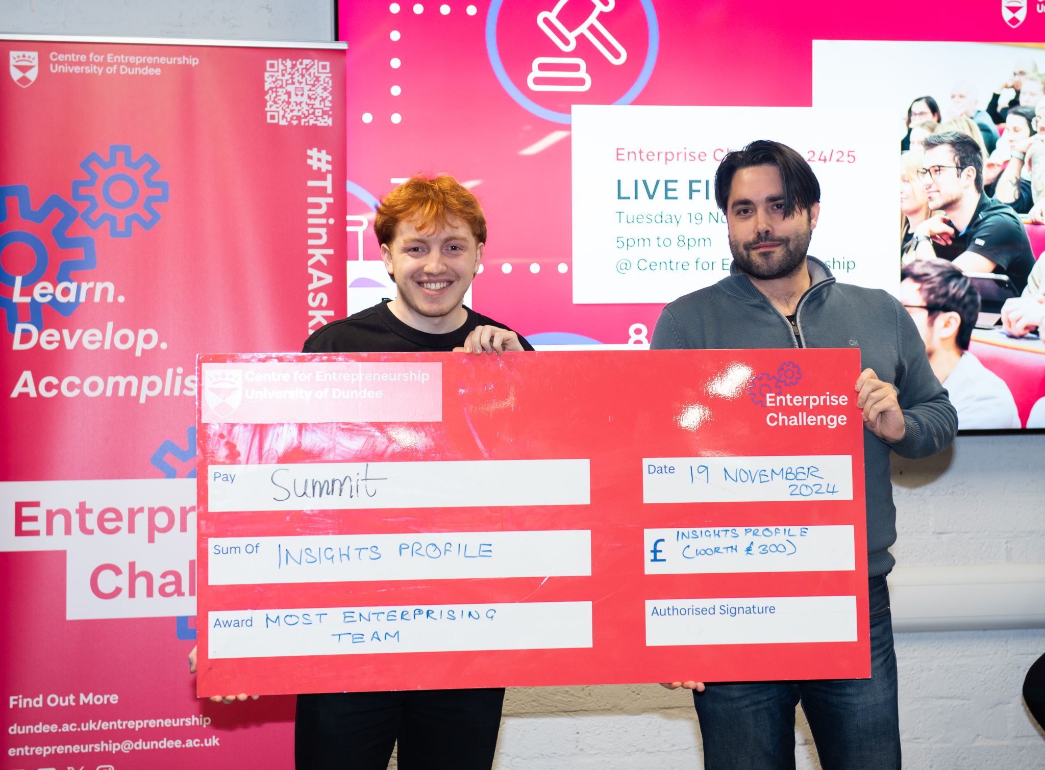 Two people holding a large cheque