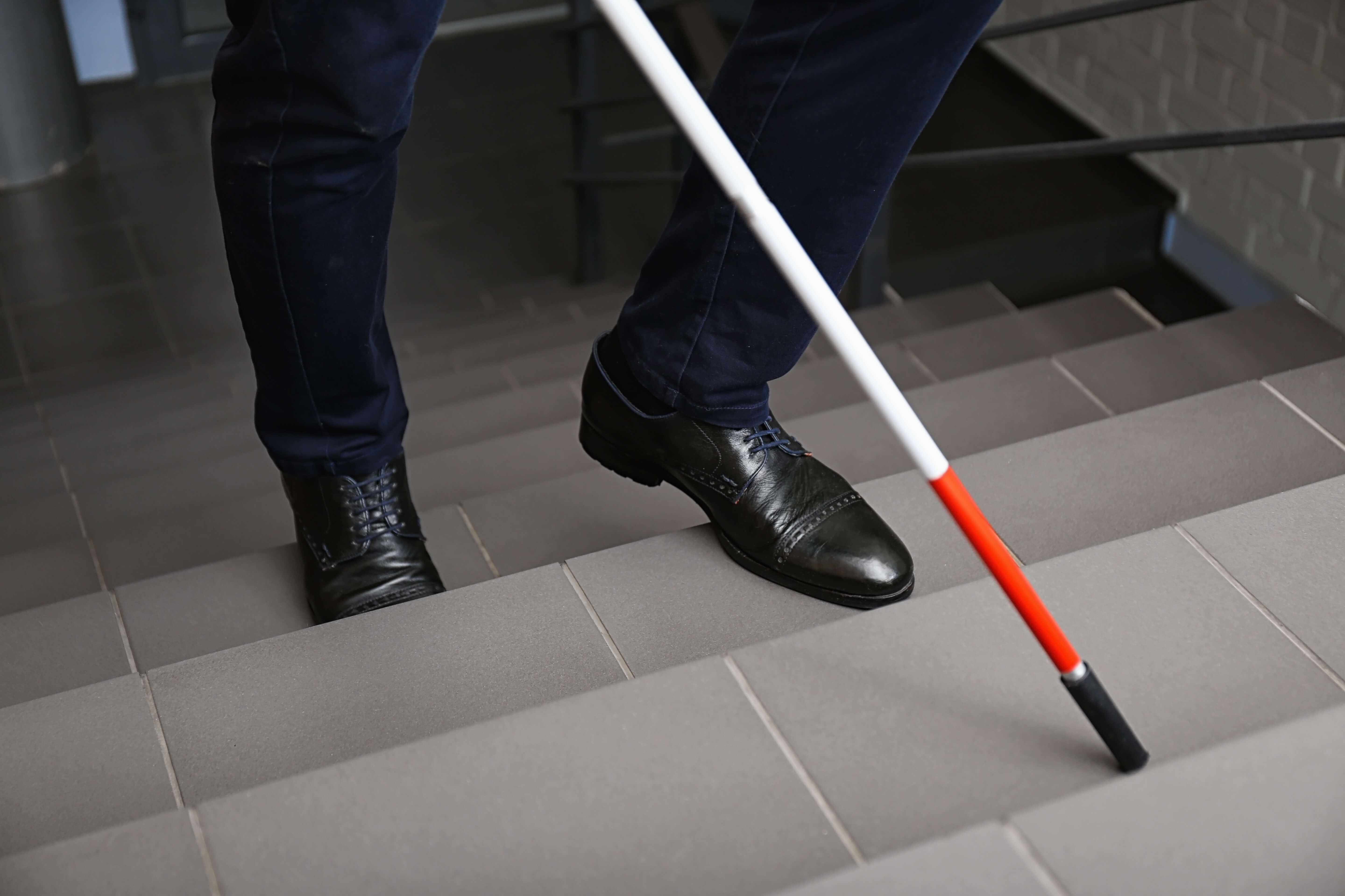 Blind person climbing stairs of an office