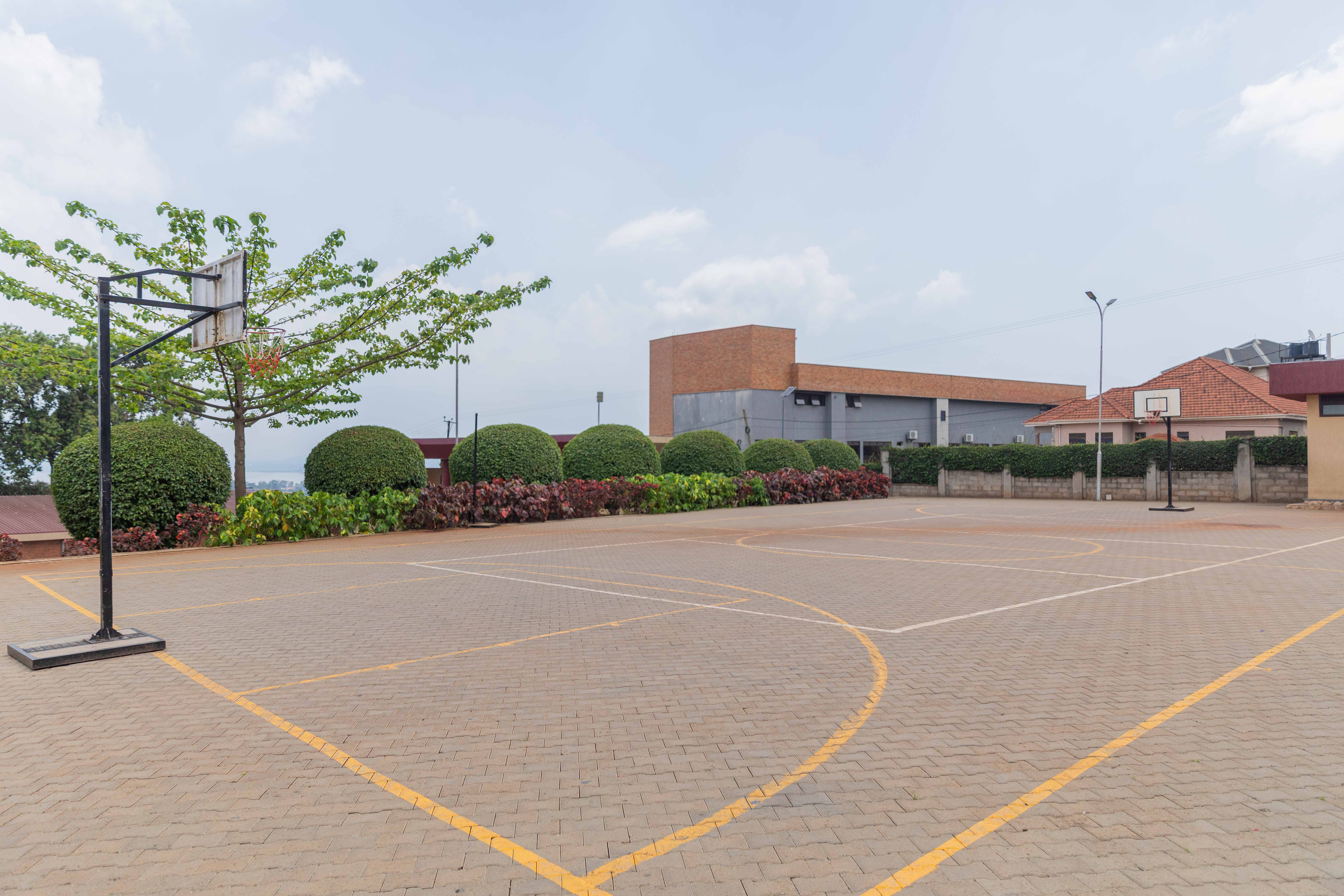 Two cheerful students are balancing books on their heads, smiling and laughing