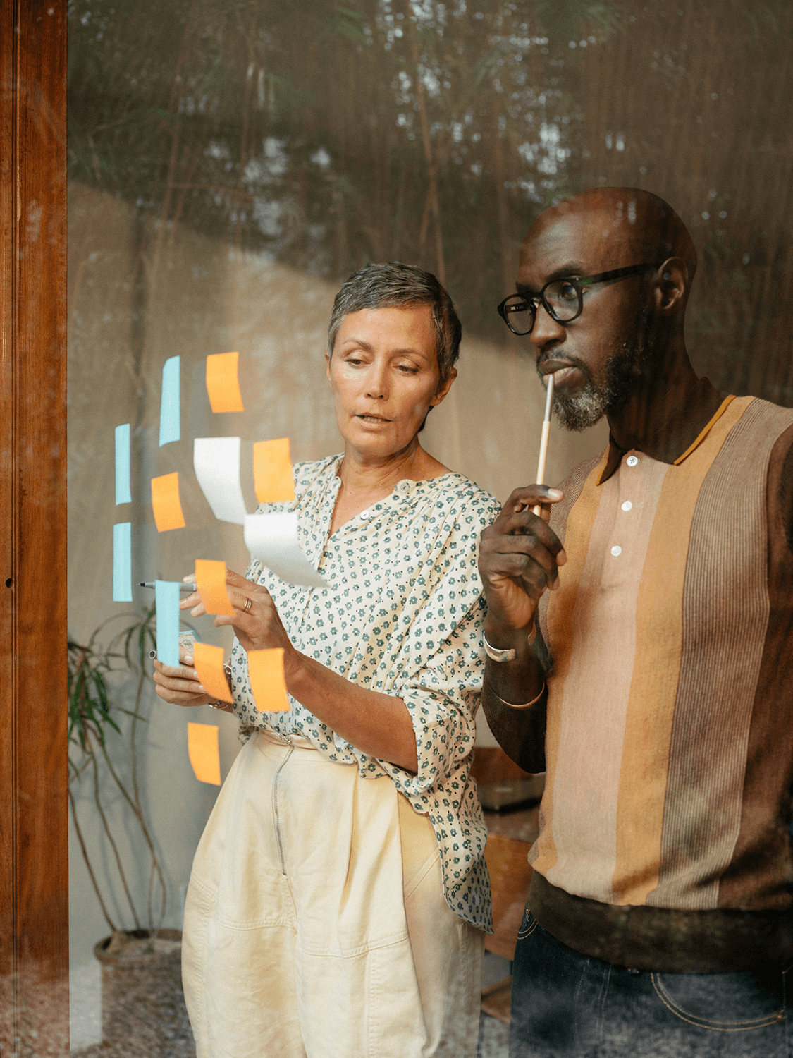 person in red sweater holding babys hand