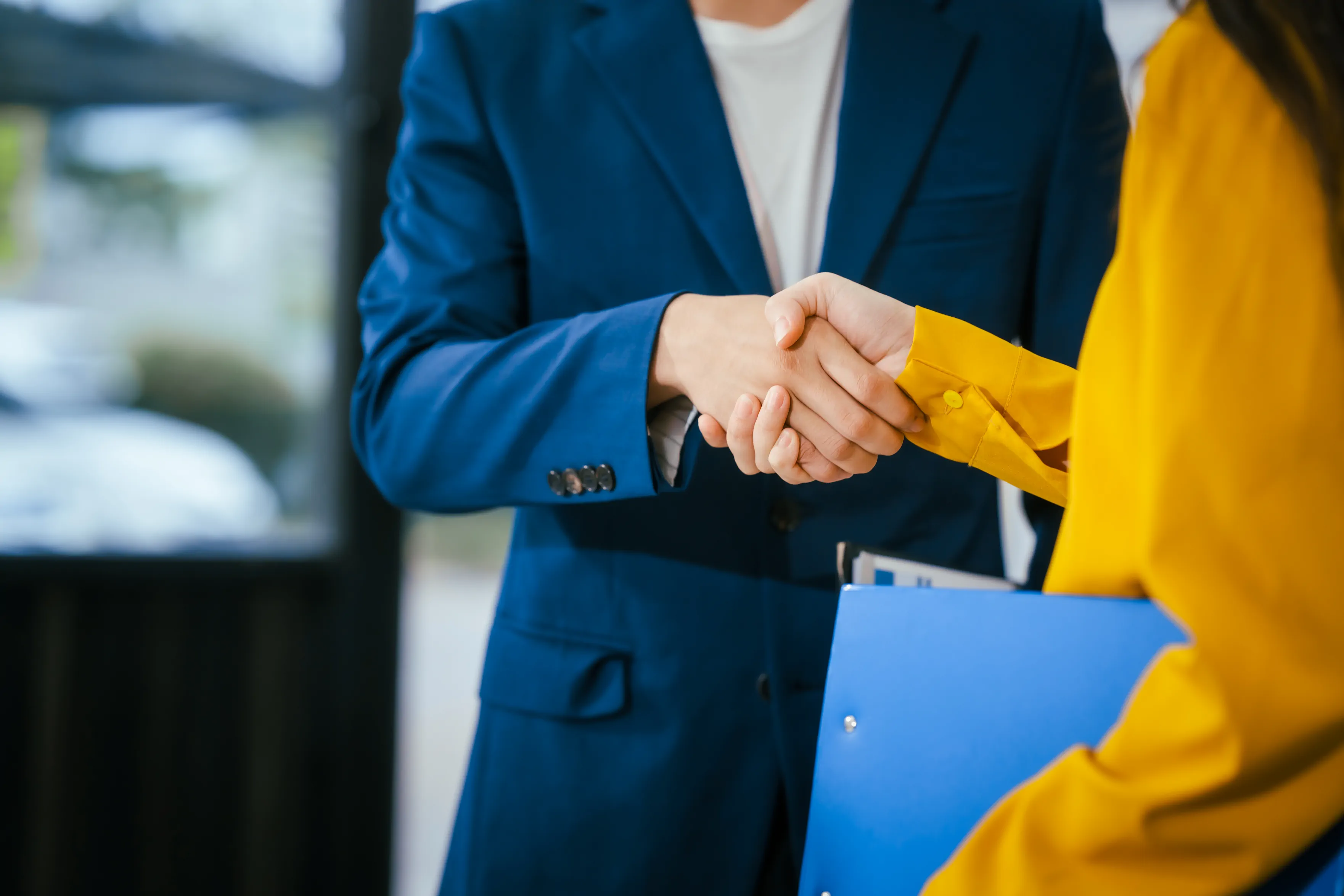 Poignée de main entre deux personnes en costume, partenariat professionnel et accord.
