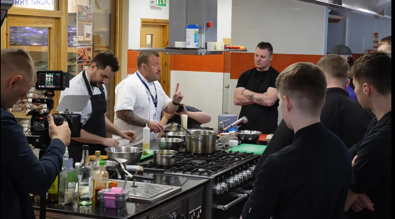 Chef instructor demonstrating techniques during a training session, filmed as part of a hospitality video production project.
