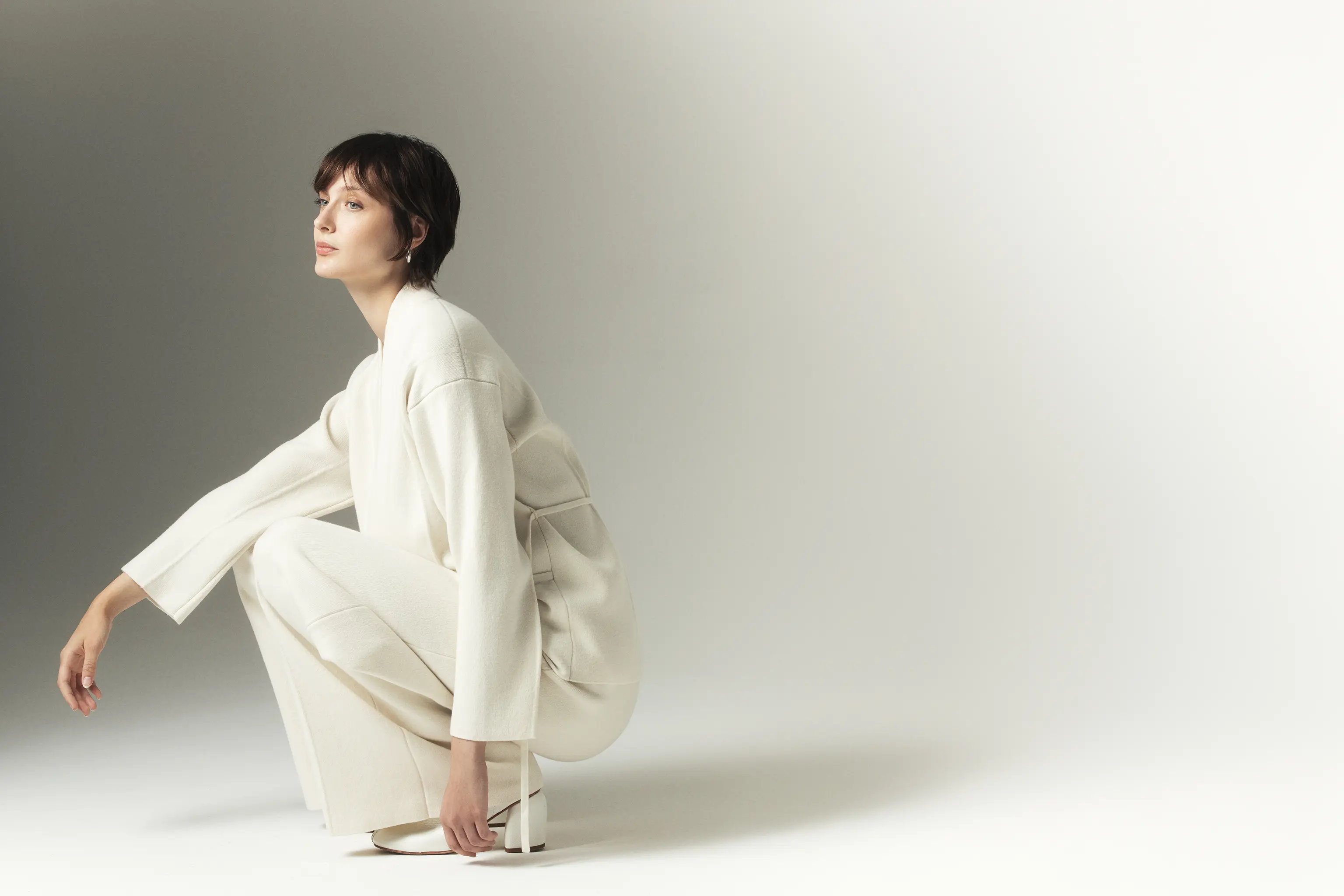 Woman in ivory cashmere wrap set – minimalist style from Aida Barni FW25/26 collection.