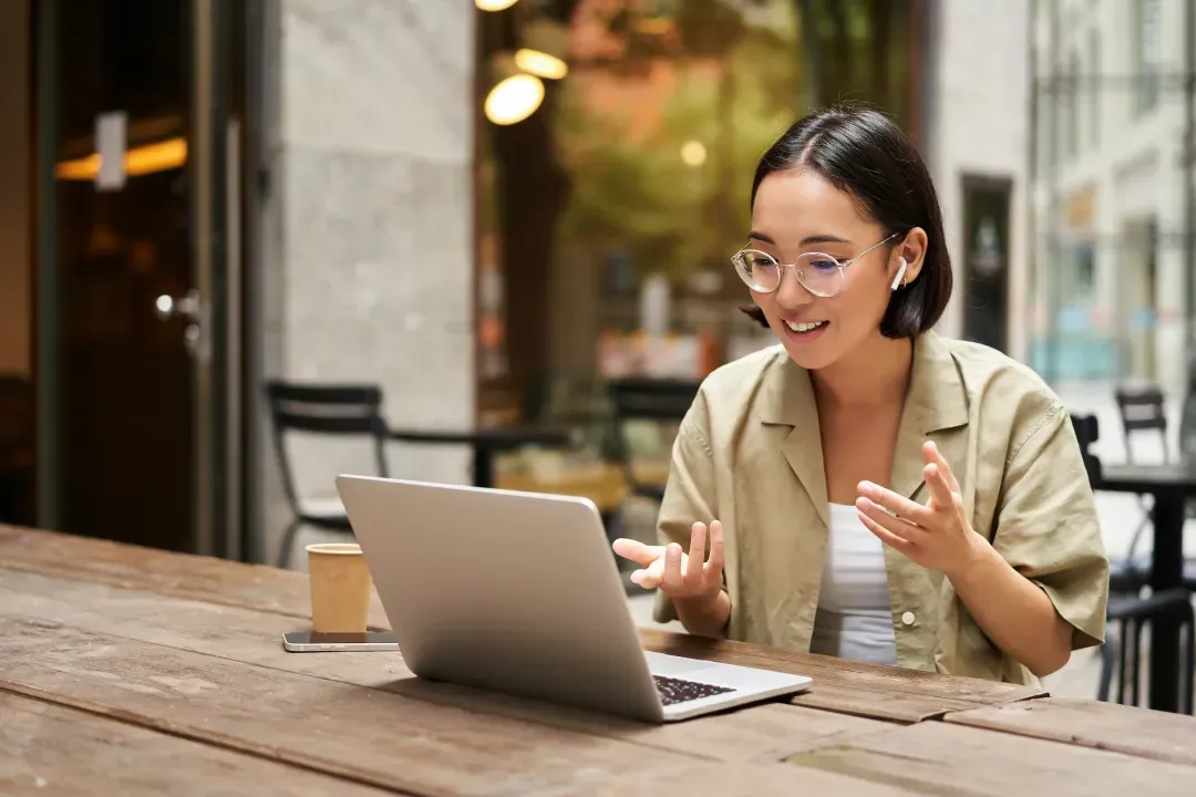 woman stting in cafe on meeting online