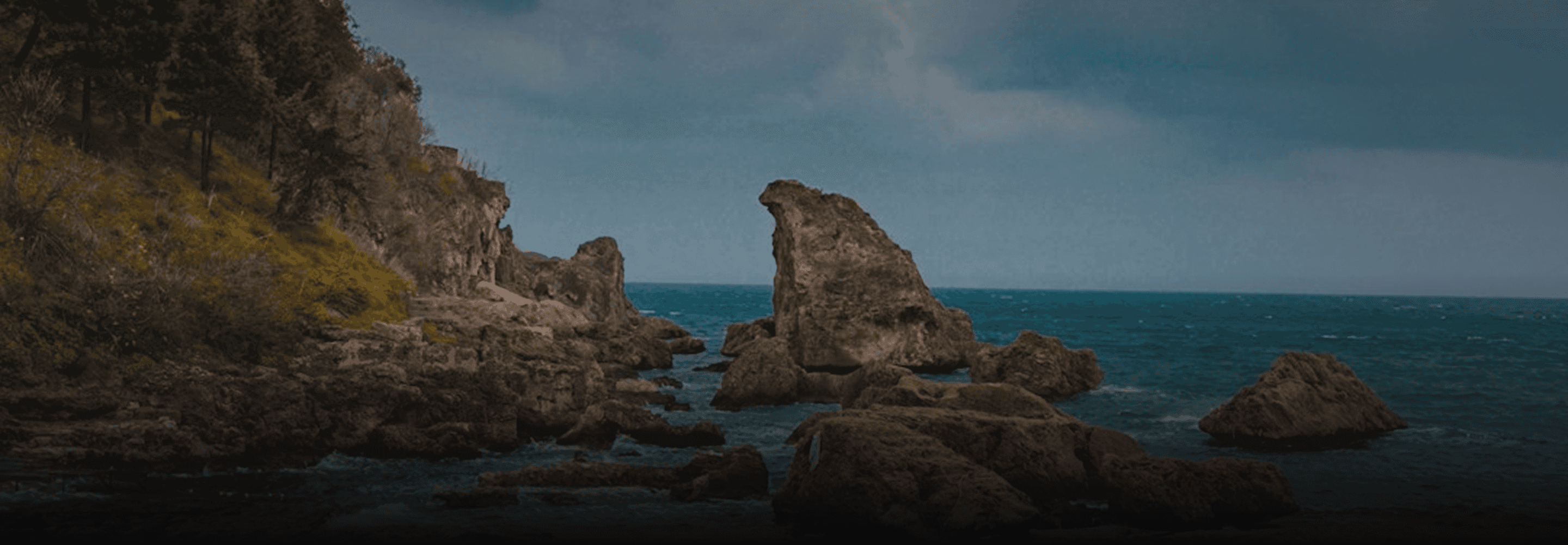 Cinematic background photograph of rugged coastal rock formations and jagged cliffs rising from a calm, deep blue sea, featured in the hero header of the Blackwood Framer template Terms of Service page.