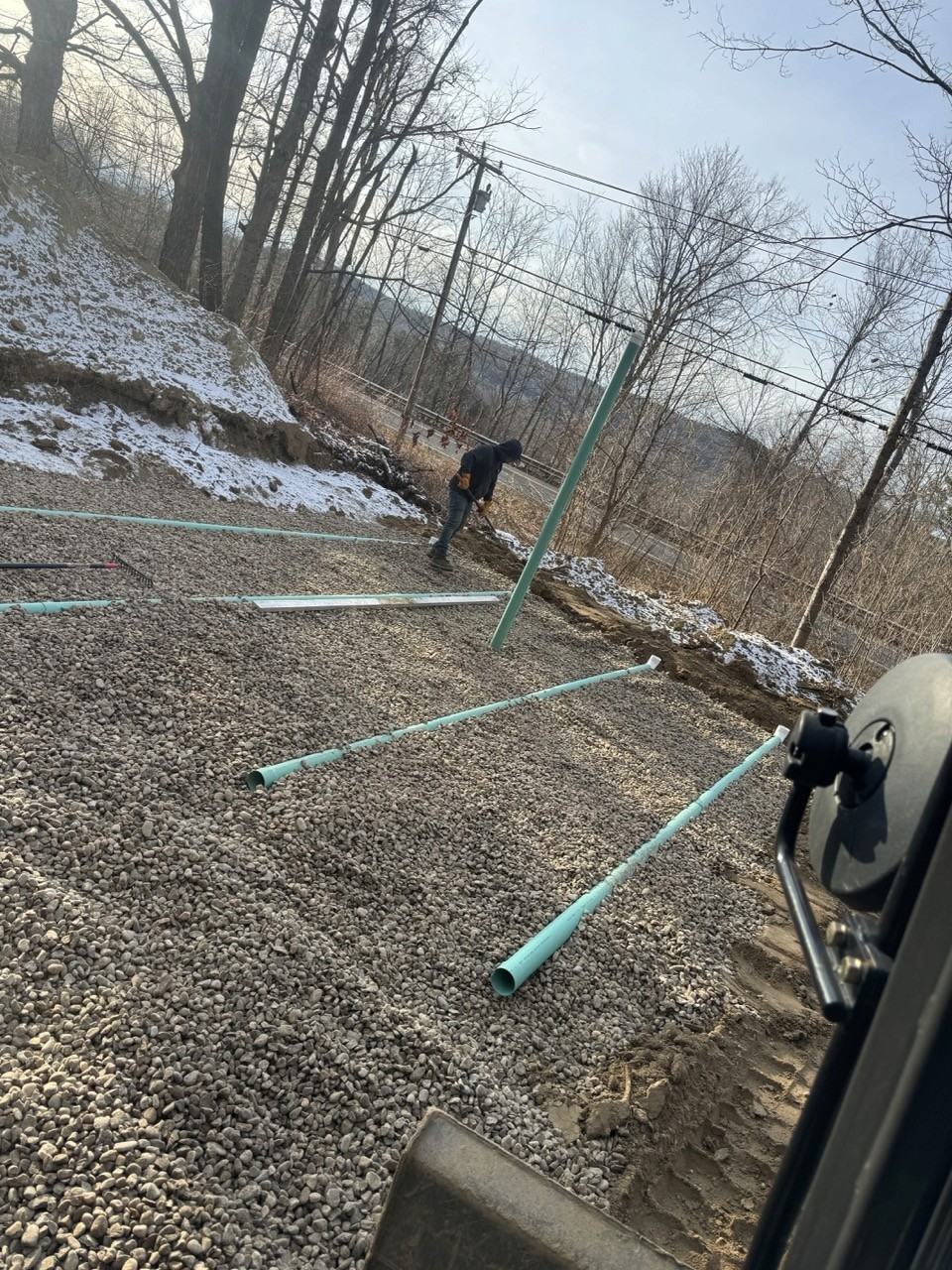 Crew setting leach field laterals in stone, by A&M Construction Enterprises