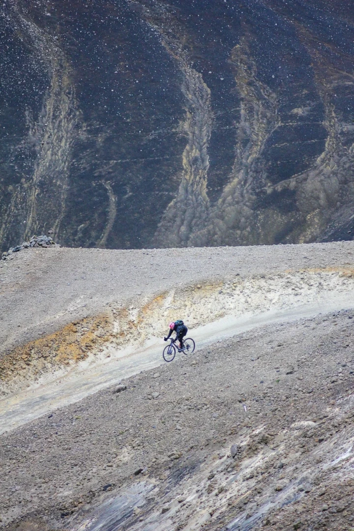 One cyclist on wide landscape with gravel riders in Iceland highlands