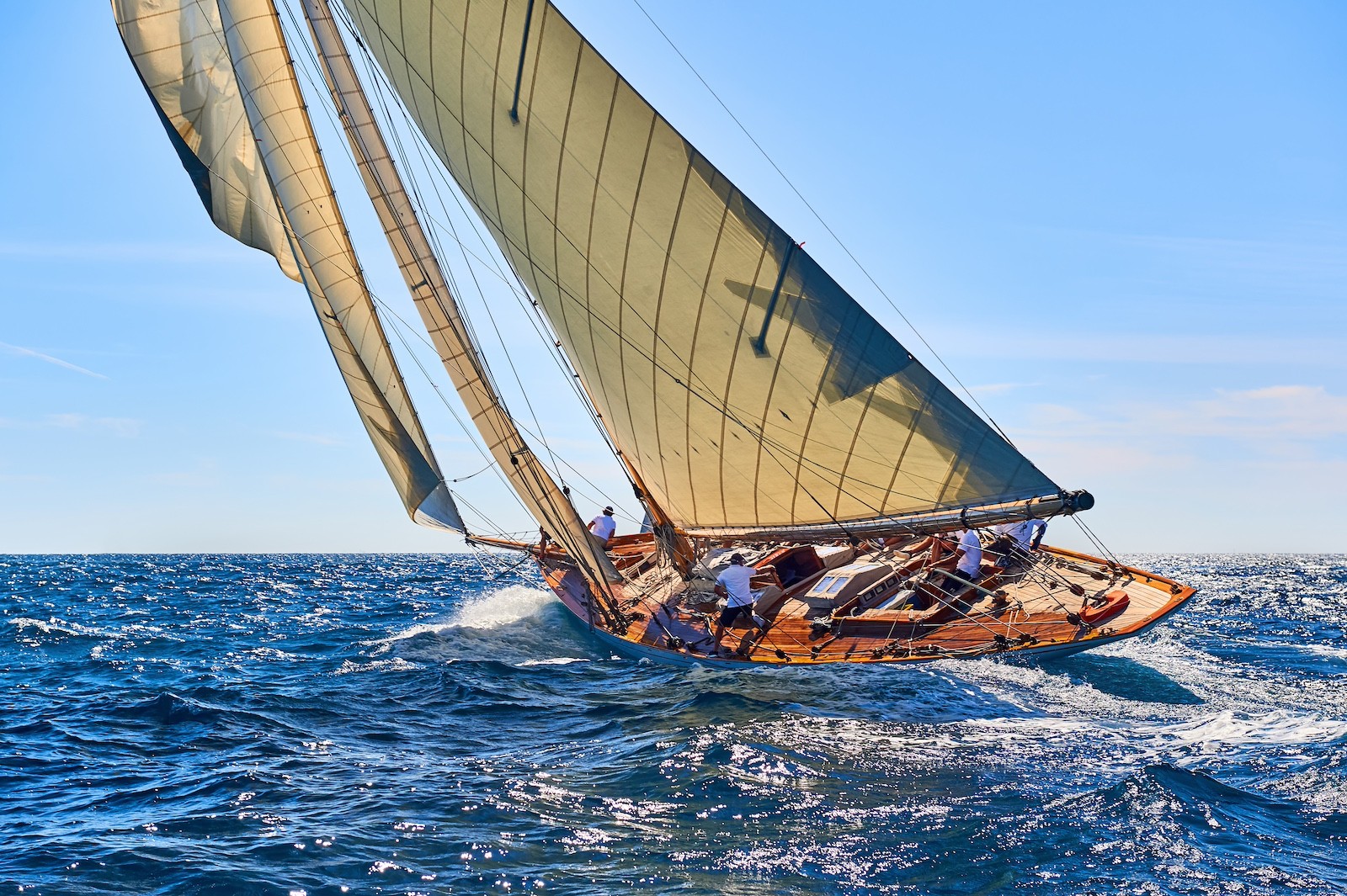 Classic sailing yacht cutting through open ocean under full sail, reflecting freedom, perspective, and the long-term outlook often associated with established private wealth.