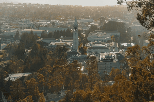 High school student conducting academic research at a desk with UC Berkeley campus in the background