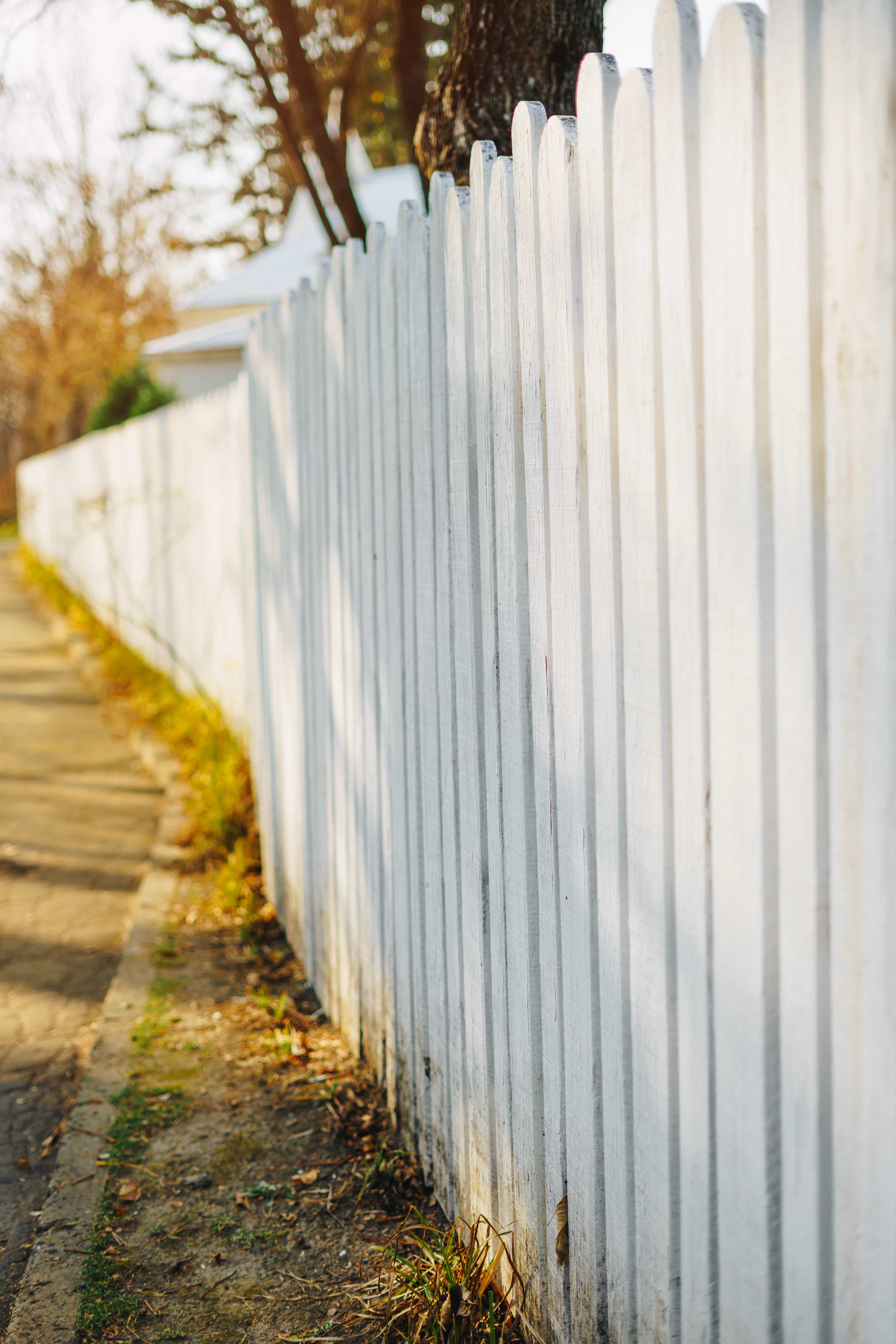 A white fence with a house in the background