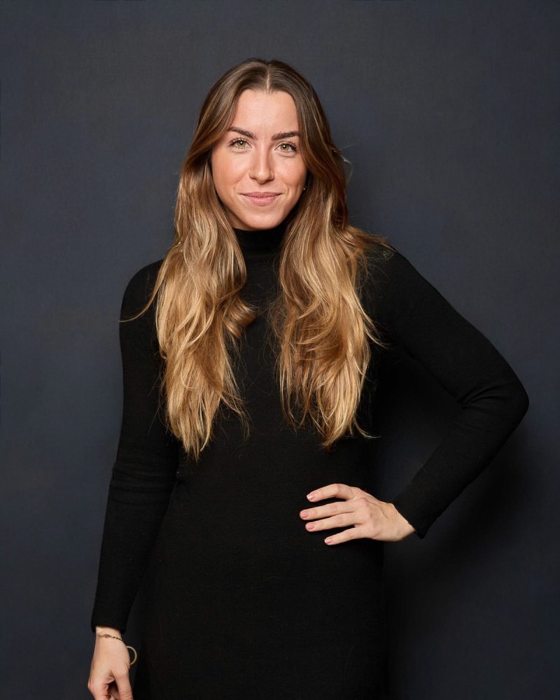 Two people focus on a laptop screen in a collaborative office setting. 