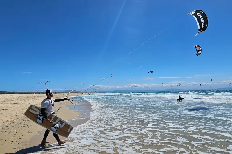 Schüler bei Explora Watersports Tarifa bereit, mit Kite und Brett ins Wasser zu gehen – sicherer Start ins Kitesurfen.