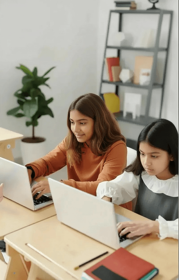 Students are seated in a classroom, focusing on their work