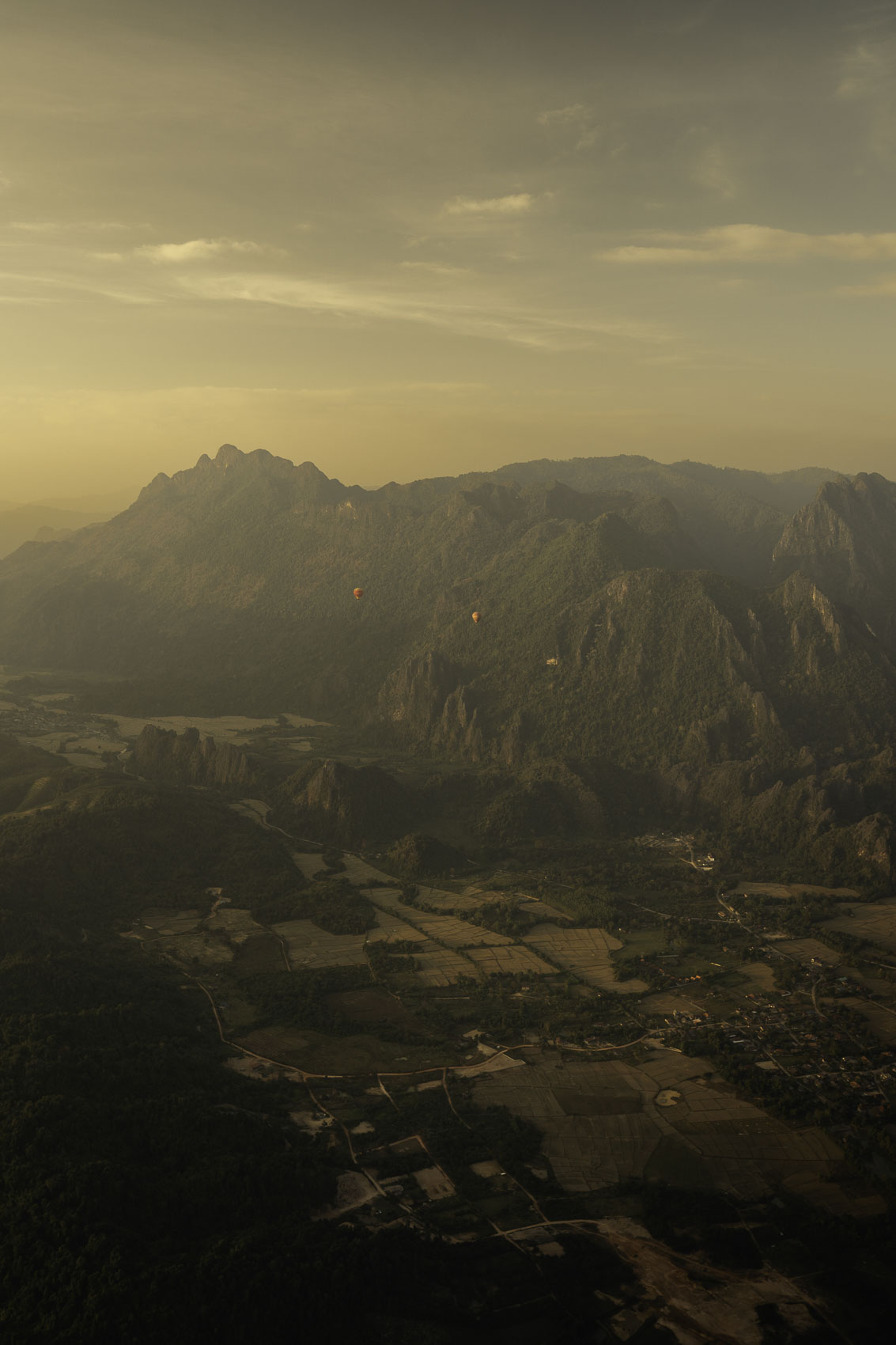 Montgolfière survolant Vang Vieng au Laos au coucher du soleil, photographie de voyage par Robin Masson