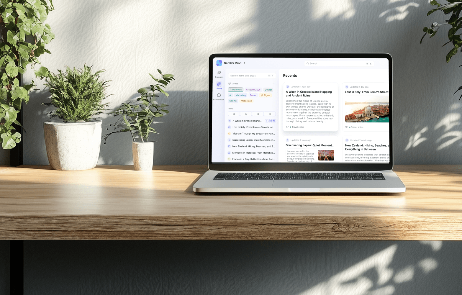 Parmind UI in the laptop on a wooden desk displays a digital note-taking app with categorized notes and travel-related articles. Green plants sit nearby